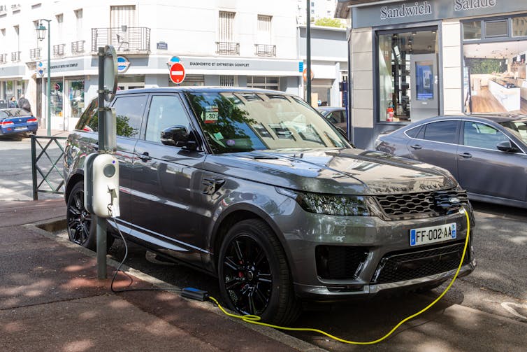 A Land Rover being charged on a Paris street.