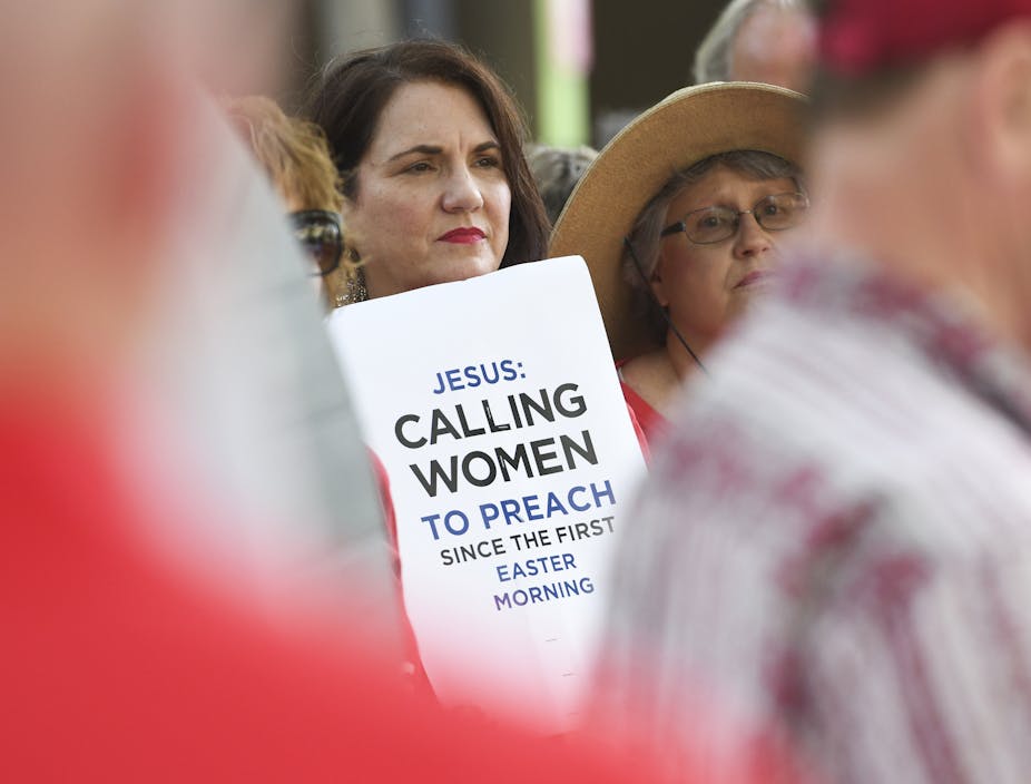 A woman holds a placard outside the Southern Baptist Convention's annual meeting in Birmingham, Alabama