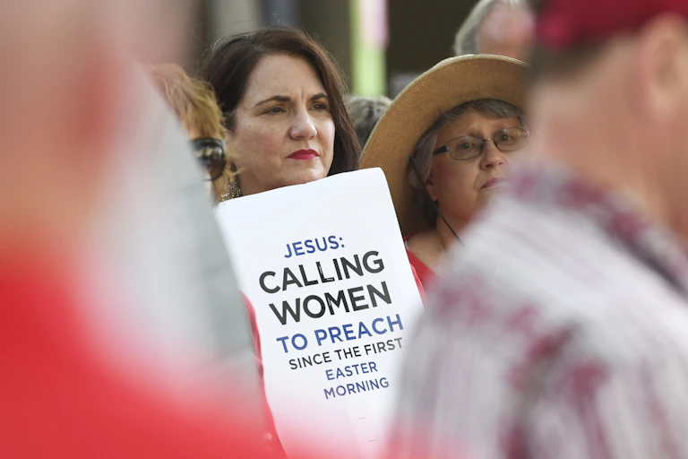 A woman holds a placard outside the Southern Baptist Convention's annual meeting in Birmingham, Alabama