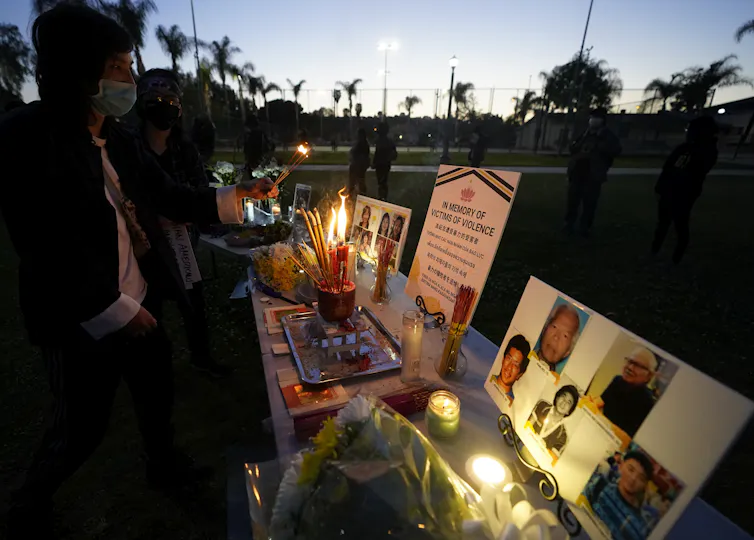 People light candles at a vigil.
