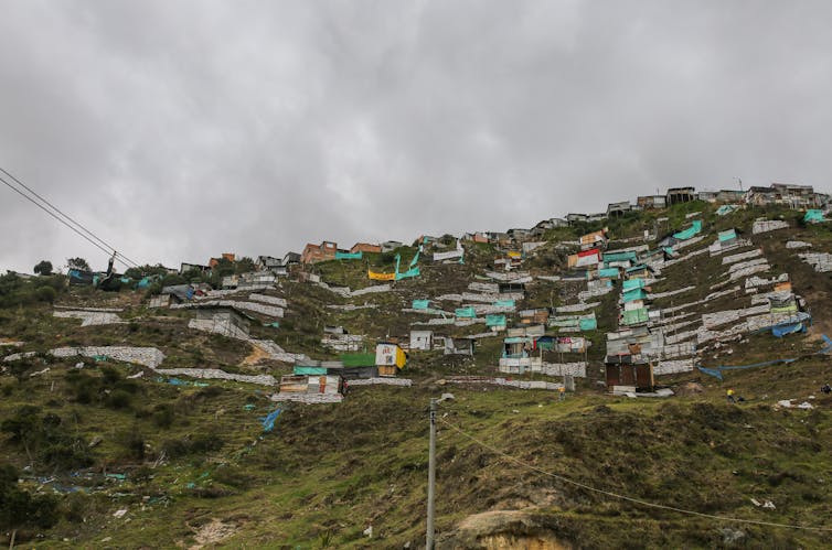 Una ladera verde con chozas en ella.