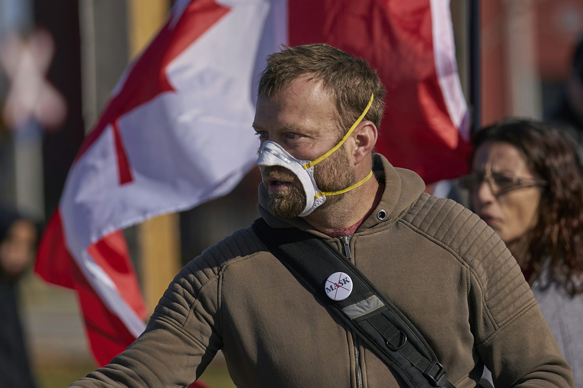 A man with a large hole cut into his face mask over his mouth and nose.