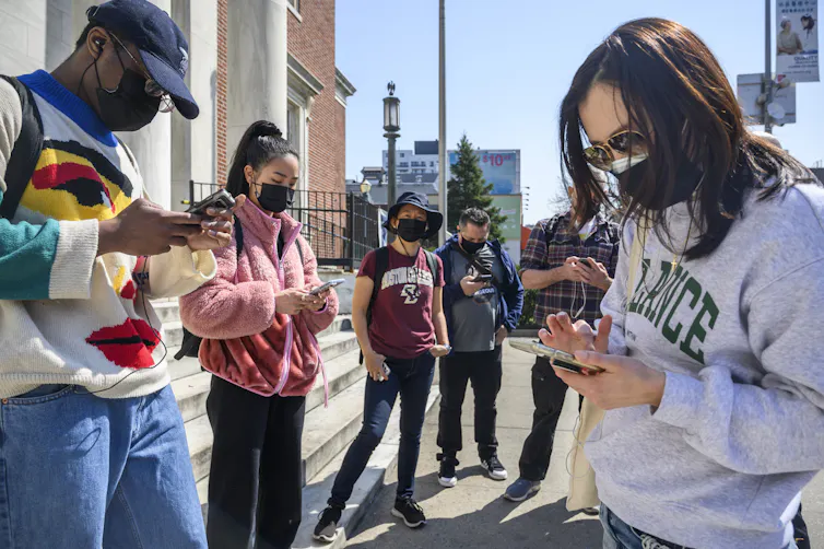 Group of people look at their phones