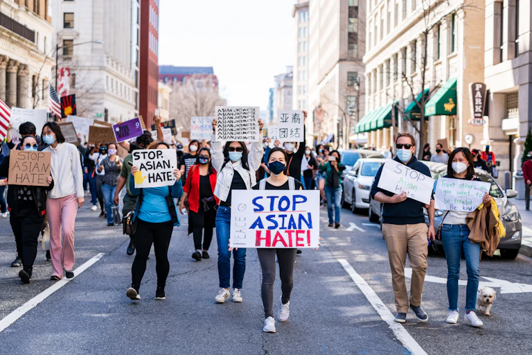 People stand with protest signs saying 'Stop Asian Hate'