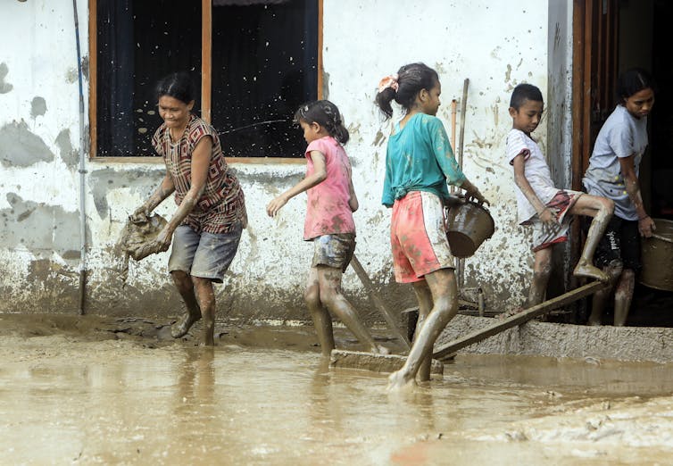 Dili residents clean up after flooding