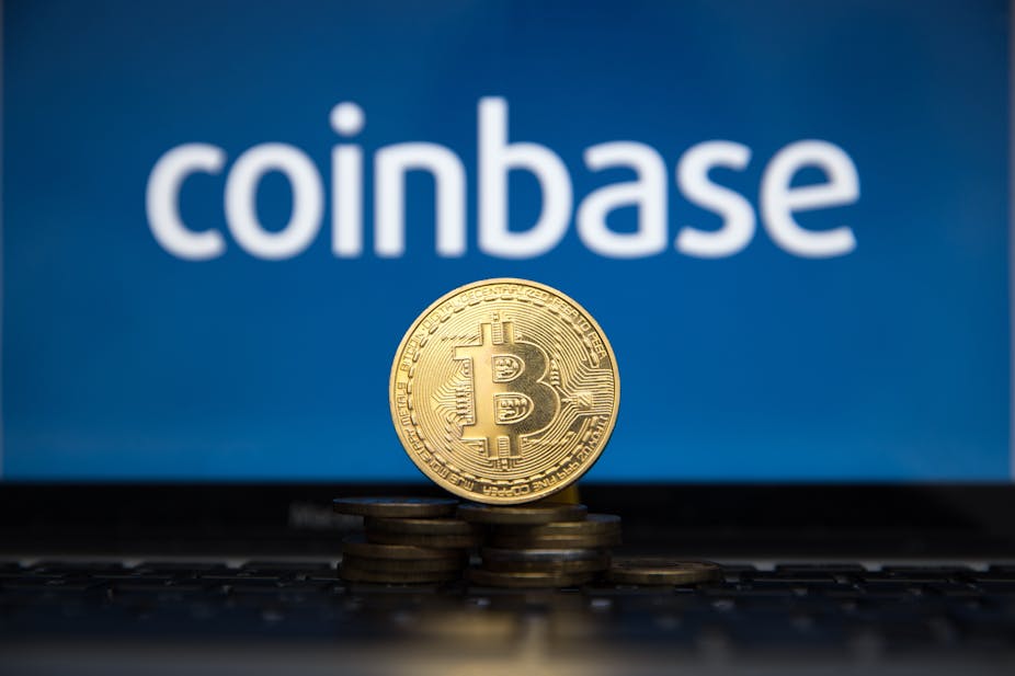 A mocked up gold bitcoin in front of the Coinbase logo
