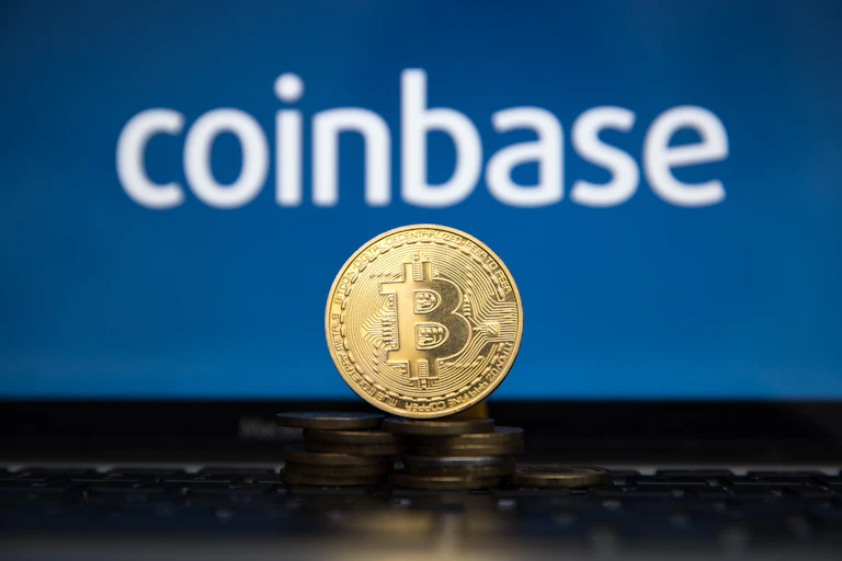 A mocked up gold bitcoin in front of the Coinbase logo