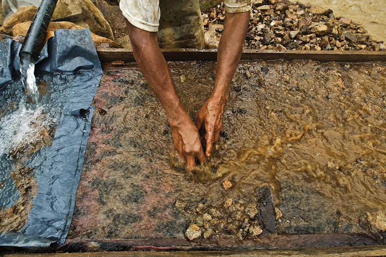 Miner washing gold ingots