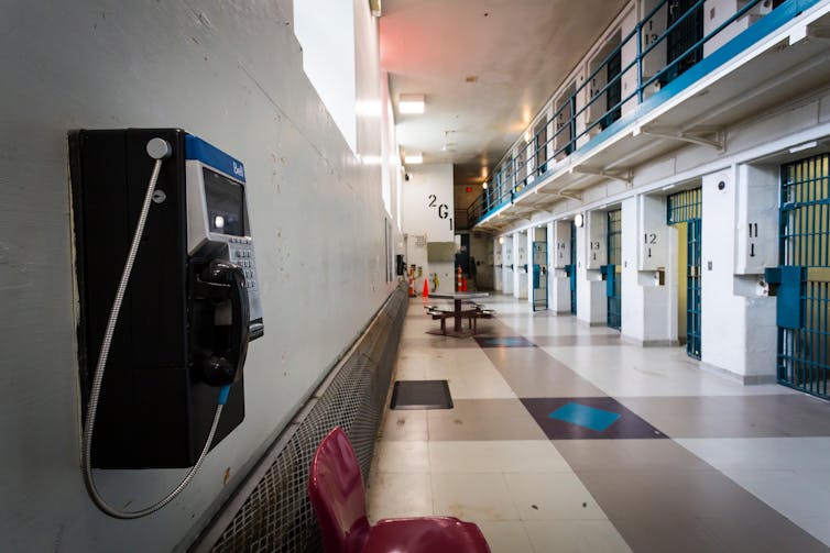 Black telephone on a wall in the hallway of a maximum security prison
