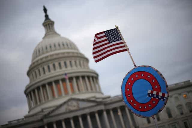 A U.S. flag adorned with a QAnon symbol flies near the U.S. Capitol.