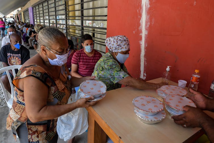 Residents receive meals at a soup kitchen in Sao Paulo.