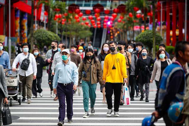 People walk down the street in Taipei, Taiwan.