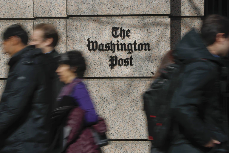 People walk in front of the Washington Post buidling