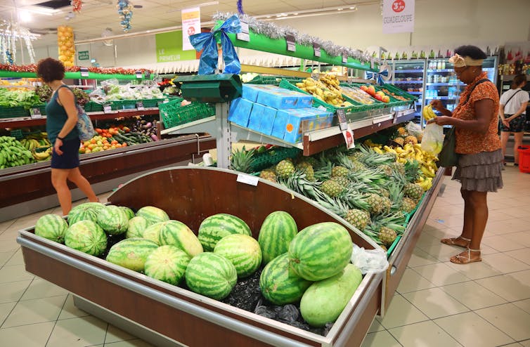 A woman shops in the produce section of a Caribbean grocery store