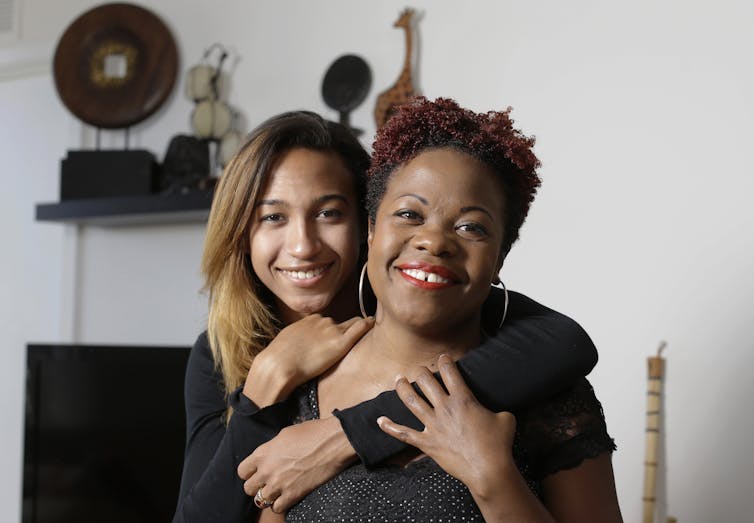 A young transgender woman hugging her mother.