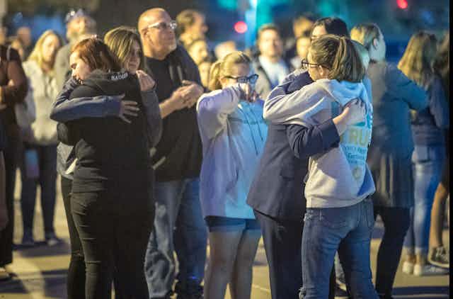 A group of children hug each other during a vigil.