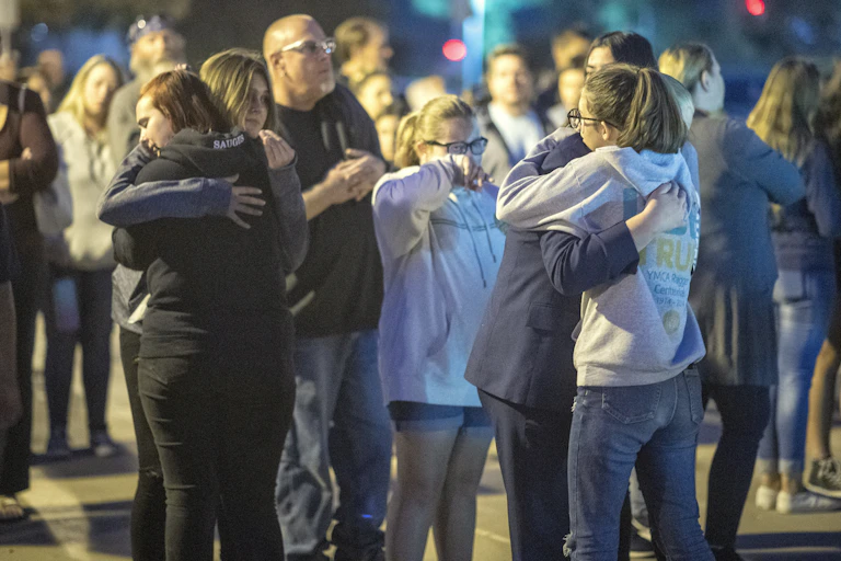 A group of children hug each other during a vigil.