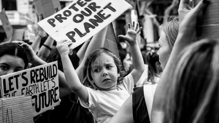 Young girl holds sign at climate protest