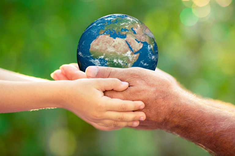 Man and child's hands holding Earth