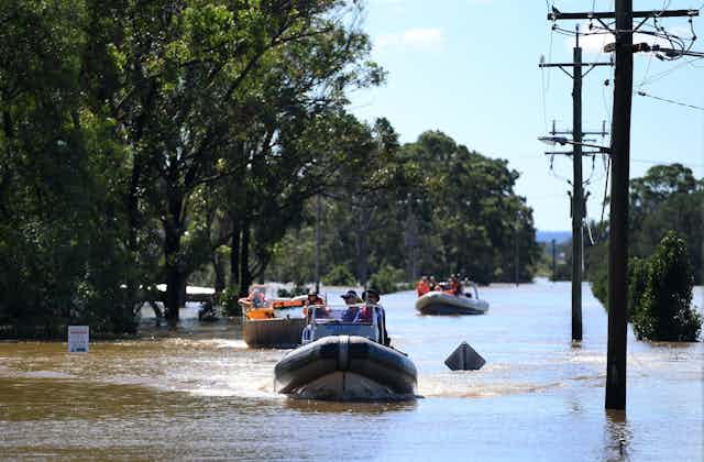 People in inflatable boats sail down a street