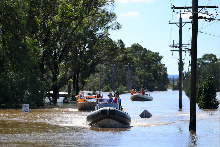 People in inflatable boats sail down a street
