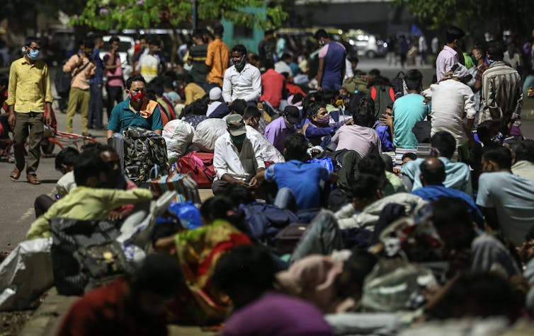 Migrant workers wait for trains in Mumbai.