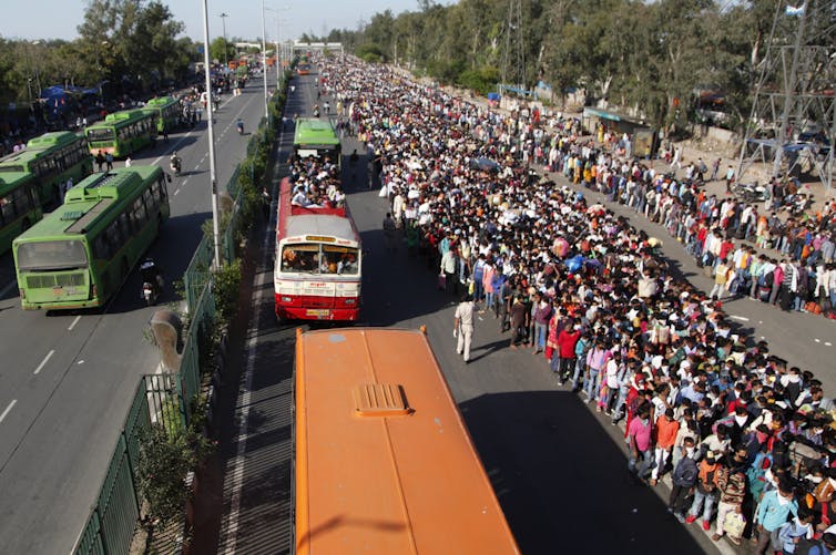 Migrant laborers wait for buses during last year's lockdown.