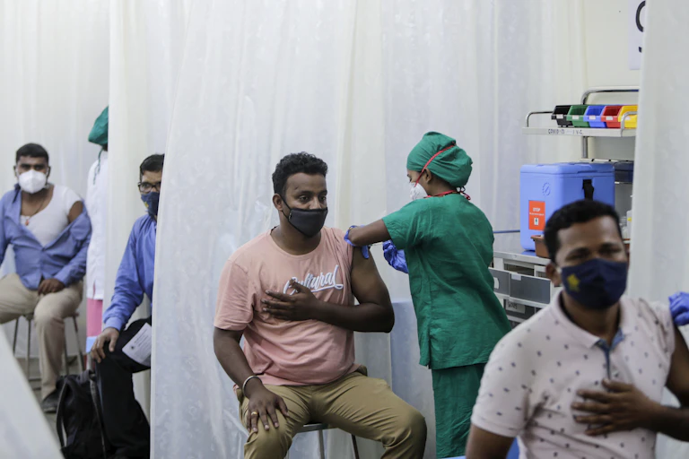 Men in a tent being vaccinated.