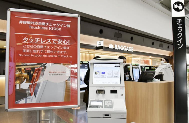 New self-service check-in machines introduced by Japan Airlines at Tokyo's Haneda airport enable passengers to complete the procedure without touching the screen.