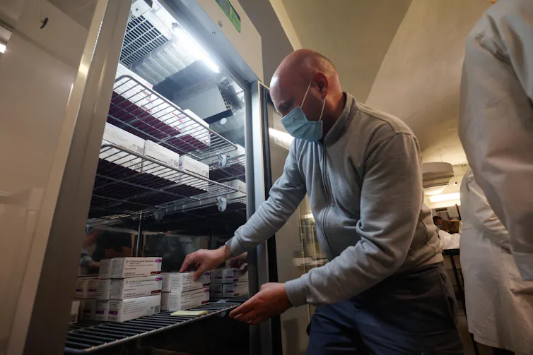 Health workers in Italy storing AstraZeneca vaccines in a fridge