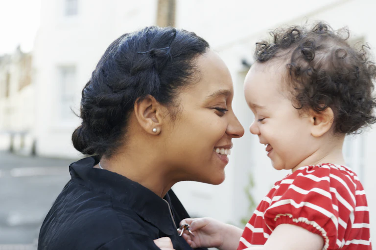 A mother and her child smile at each other.