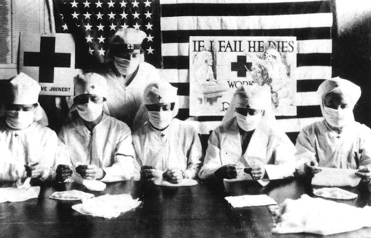 Red Cross volunteers from 1918 wearing masks.