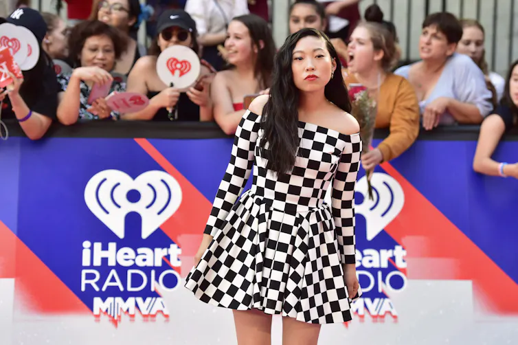 Woman standing on red carpet in checkered dress