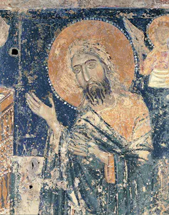Christ with lifted arms, his head encircled by a halo, or nimbus, wearing a tunic and a mantle.