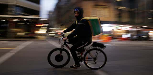A food delivery rider on an electric bicycle.