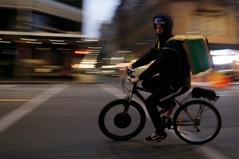 A food delivery rider on an electric bicycle.