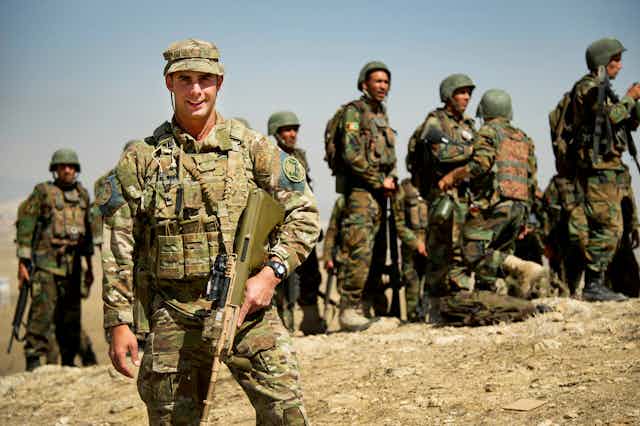 Australian Army soldier standing in front of Afghan officers