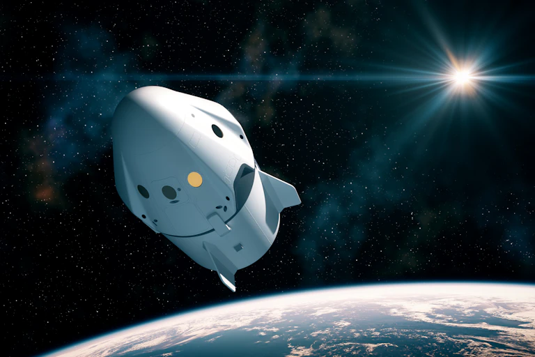 An artistic rendering of the Crew Dragon capsule floating through space above Earth.