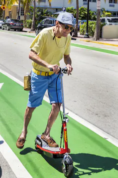 Older man on a scooter in a bike lane