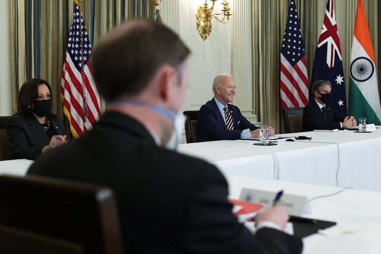 Vice President Kamala Harris, President Joe Biden and Secretary of State Anthony Blinken at meeting tables with flags