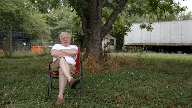 Man sits in lawn chair.