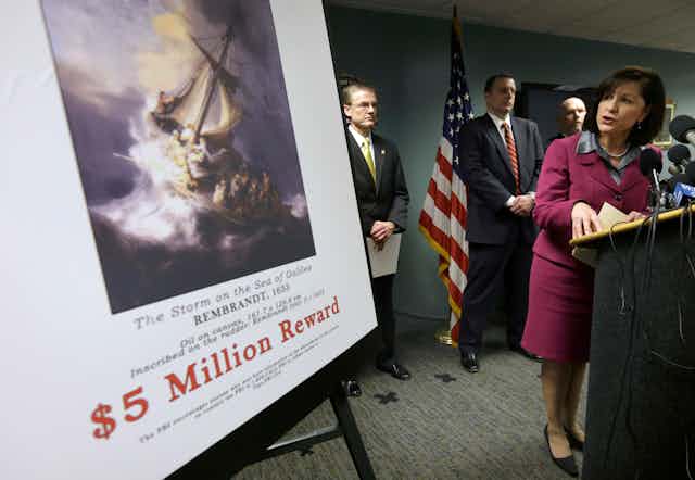 FBI agents with reward poster for missing art.