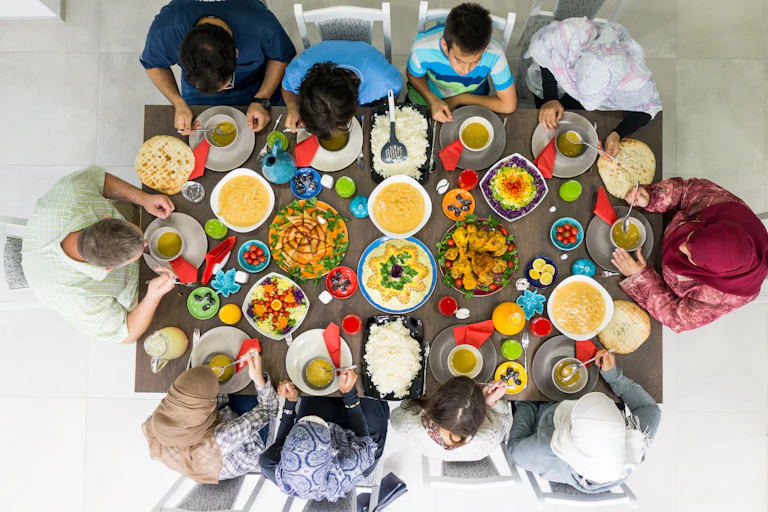 A Muslim family sitting down to eat a big meal during Ramadan.