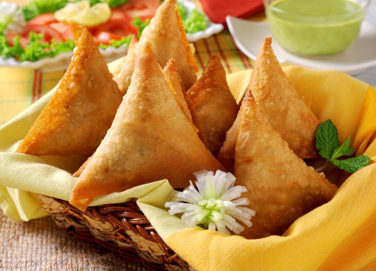 A basket of fried samosas.