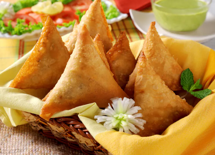 A basket of fried samosas.