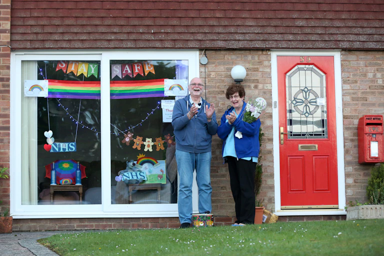 A couple clap for carers outside their home