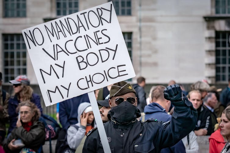 A protestor holds a 'No mandatory vaccines' placard.