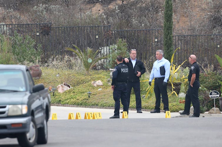 Police gathered outside a house where a man with a rifle was shot.