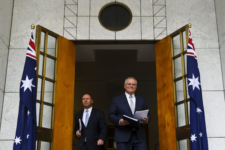 Treasurer Josh Frydenberg and Prime Minister Scott Morrison walking through a doorway.