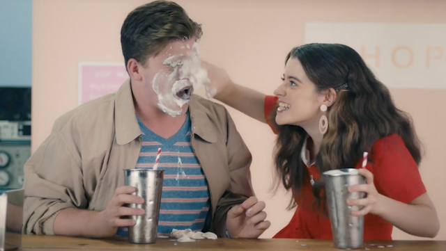Girl smearing milkshake over boy's face